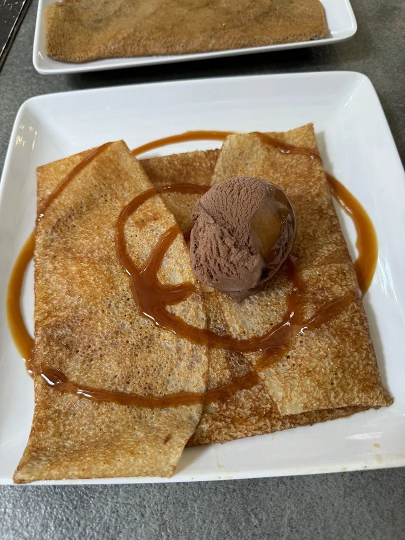 Crêpe au caramel beurre salé pliée, nappée de caramel et boule de glace chocolat